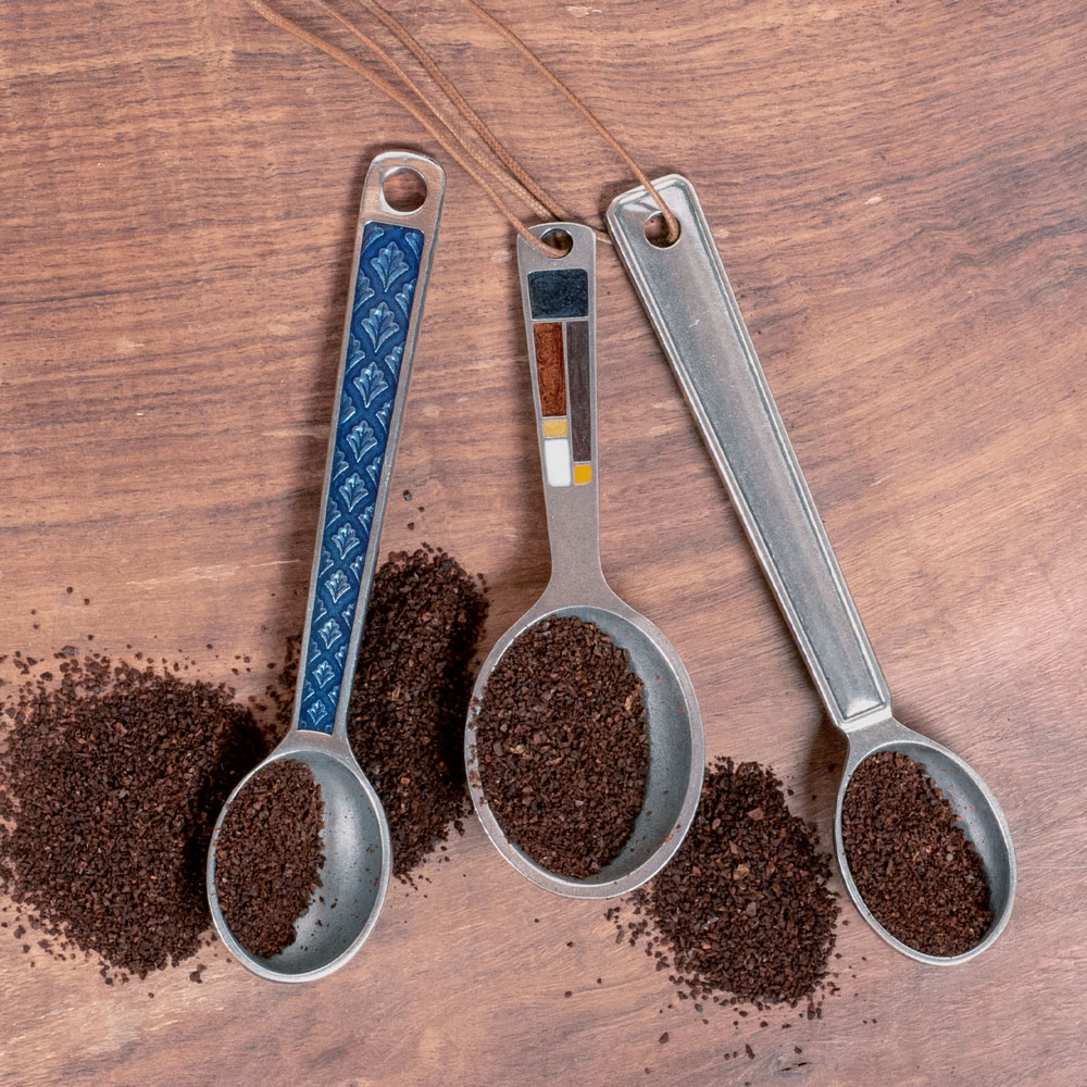 3 different coffee scoops lying on a counter