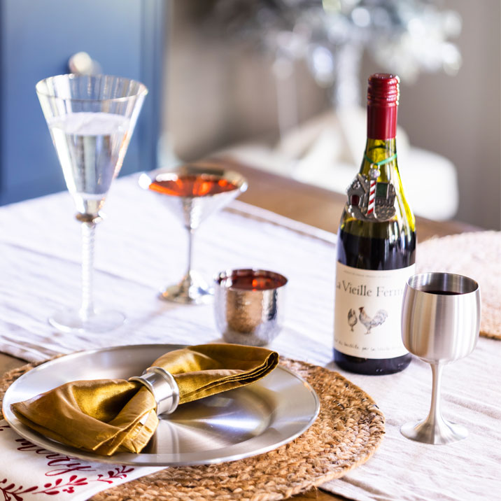 Holiday tablesetting showing pewter plates, napkin rings, and barware