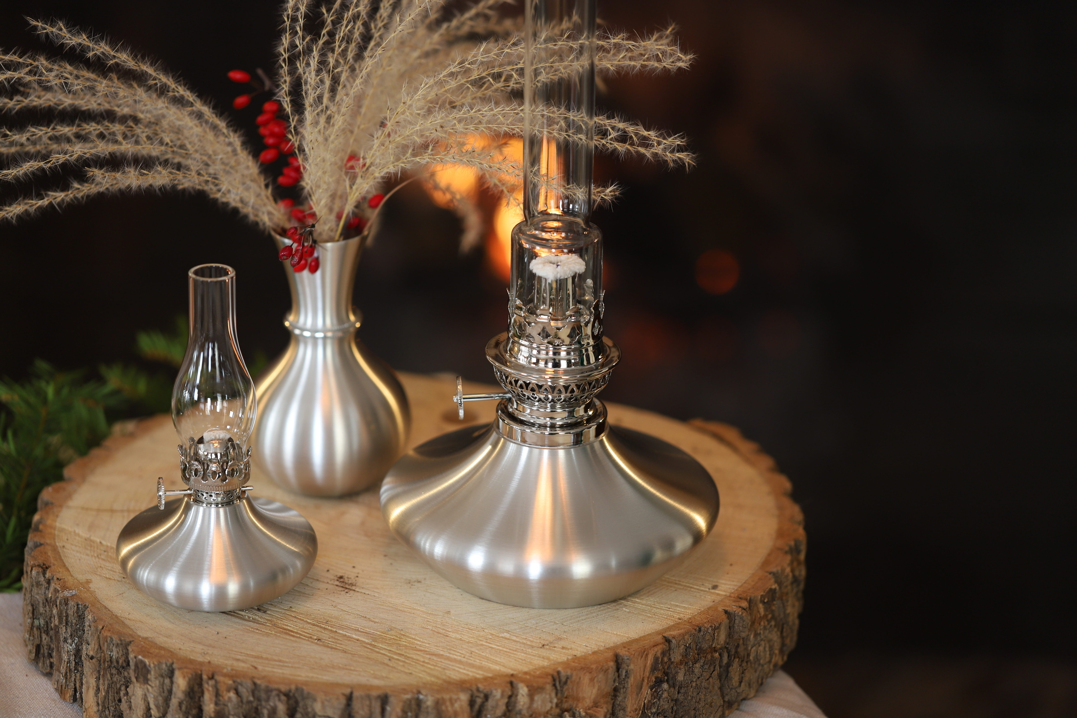 2 oil lamps and a vase in front of a fireplace